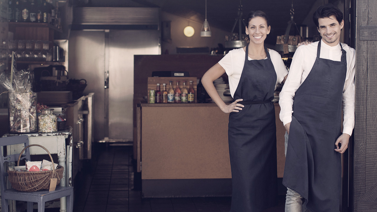 Two waiters welcoming into restaurant