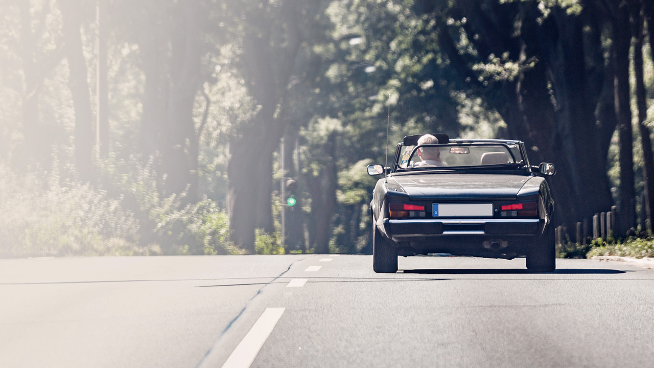 Mann som kjører cabriolet.